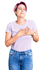 Poster - Young beautiful woman with pink hair wearing casual clothes smiling with hands on chest with closed eyes and grateful gesture on face. health concept.