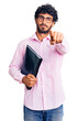© Krakenimages.com - Handsome young man with curly hair and bear holding business folder pointing with finger to the camera and to you, confident gesture looking serious