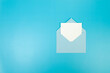 © STUDIA818 - Top view of light blue envelope, white card on blue background. Post flat lay. Copy space.