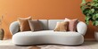 Curved sofa in front of an orange wall