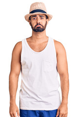 Poster - Young hispanic man wearing casual summer hat depressed and worry for distress, crying angry and afraid. sad expression.