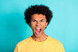 Photo of aggressive mad guy with afro hairdo dressed yellow t-shirt screaming wide open mouth isolated on turquoise color background