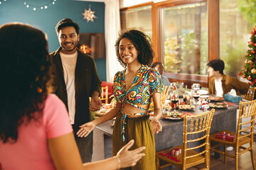 Wall Mural - Happy friends enjoying in conversation during festive dinner at home party