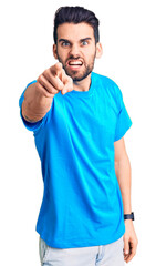 Wall Mural - Young handsome man with beard wearing casual t-shirt pointing displeased and frustrated to the camera, angry and furious with you