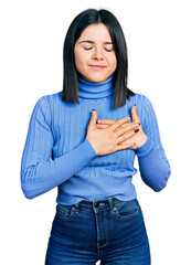 Poster - Young brunette woman with blue eyes wearing casual turtleneck sweater smiling with hands on chest, eyes closed with grateful gesture on face. health concept.