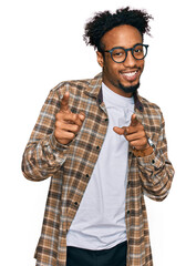 Wall Mural - Young african american man with beard wearing casual clothes and glasses pointing fingers to camera with happy and funny face. good energy and vibes.