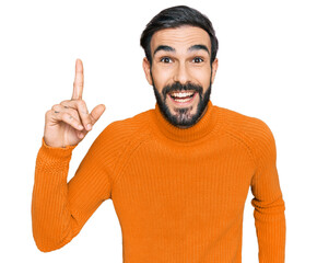 Poster - Young hispanic man wearing casual clothes pointing finger up with successful idea. exited and happy. number one.