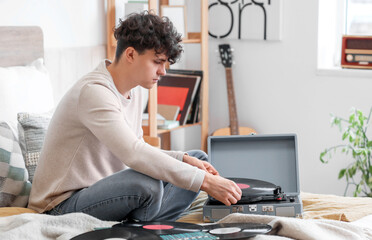 Wall Mural - Young man with vinyl disks and record player in bedroom