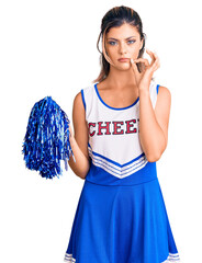 Canvas Print - Young beautiful woman wearing cheerleader uniform mouth and lips shut as zip with fingers. secret and silent, taboo talking