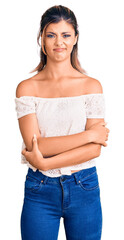 Poster - Young beautiful woman wearing casual clothes skeptic and nervous, disapproving expression on face with crossed arms. negative person.