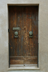 Wall Mural - Old wooden door with decorative elements in city