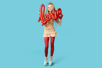 Wall Mural - Young happy woman with vintage roller skates and balloon in shape of word LOVE on blue background