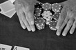 Closeup of hands betting chips in poker, black and white