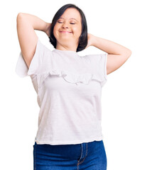 Wall Mural - Brunette woman with down syndrome wearing casual white tshirt relaxing and stretching, arms and hands behind head and neck smiling happy