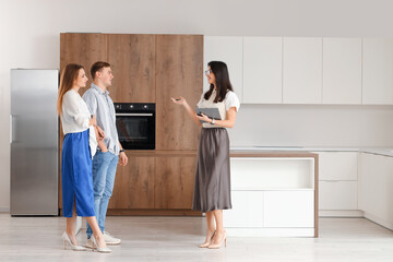 Canvas Print - Female real estate agent showing couple kitchen in new house