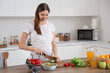 © Pixel-Shot - Beautiful pregnant woman cutting cucumber in kitchen