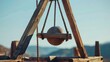 A metal ball hanging from a wooden structure. Perfect for industrial designs