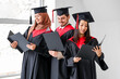 © Pixel-Shot - Graduate students with diplomas in light room