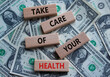 Health symbol. Wooden blocks with words Take Care of your Health. Beautiful dollar background. Health concept. Copy space.
