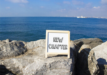 Wall Mural - New Chapter symbol. Concept word New Chapter on white chalk background. Beautiful sea background. Business and New Chapter concept. Copy space