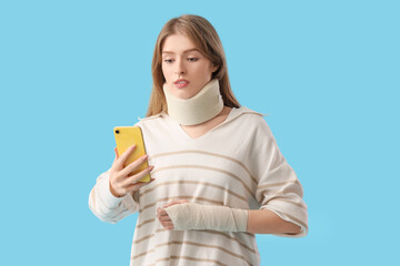 Canvas Print - Injured young woman after accident with mobile phone on blue background