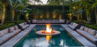 An opulent getaway by the pool including a submerged fire pit, encircled by soft cushions and verdant foliage