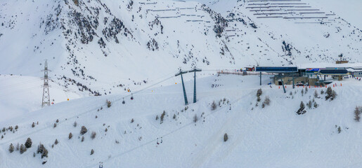 Wall Mural - Aerial shot of Verbier, Switzerland shows snow slopes, ski lifts, and cable cars on the mountain. Skiers hit trails with facilities at the base.