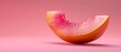   A close-up of a slice of fruit on a pink background with a nibble taken from it