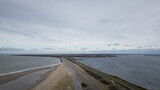 Fototapeta Miasto - Aerial view drone shot of dam road N57 brouwersdam between north sea and Zeeland salt water lake Grevelingenmeer. Dutch industrial engineering frontier protecting country land from flooding