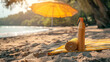 Sunscreen and towel on a sunny beach with umbrella in background