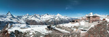 Fototapeta Do pokoju - Aerial panoramic view of the Verbier ski resort town in Switzerland. Classic wooden chalet houses standing in front of the mountains. 