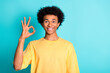 Photo of satisfied guy with afro hair dressed yellow t-shirt showing okey approve good work isolated on turquoise color background