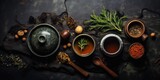 Fototapeta  - flat lay arrangement on a dark textured background. There's a set of wooden stumps alongside a cup of tea. Bowls filled with tea herbs sit nearby, ready to be brewed. 