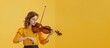 Young woman playing violin on yellow background