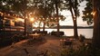 Travel trailer parked by the lake with outdoor seating and garlands. The setting sun colors its sleek exterior with warm hues, creating an atmosphere for outdoor relaxation.