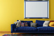 A vibrant Scandinavian living room featuring a cobalt blue sofa against a lemon yellow wall. One blank empty mock-up poster frame in a silver finish provides a sleek and modern contrast