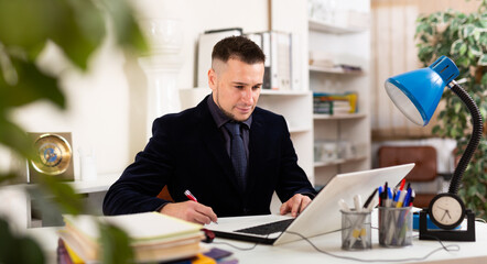 Wall Mural - Portrait of smiling young adult man entrepreneur at work in office