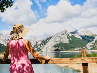 Tourist contemplating the Riaño reservoir on a sunny summer day, León province, Community of Castilla y León, Spain.