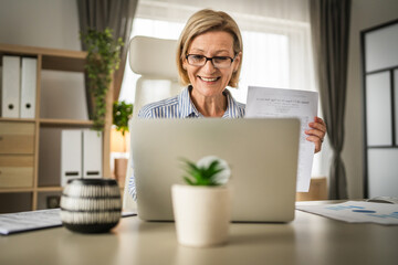 mature woman businesswoman have video call use laptop at office