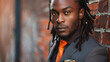 A closeup of a young black man gazing into the camera with selfassuredness sporting a fitted suit with a pop of color in his pocket square. His stylish dreadlocks cascade down his .