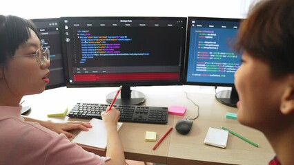 Slow motion back end software developer engineer for computer programming working together on debugging writing computing code, solving complex algorithms display on monitor in office. Burgeoning