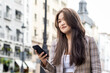 © PEDROMERINO - Young Asian Woman Walking and Using Smartphone in the City