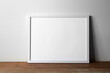 Minimalist mockup poster white frame laying on the wooden table