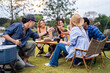 © Kawee - Group of diverse friend having outdoors camping party together in tent.