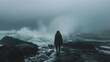 Against a backdrop of swirling ocean waves and a misty horizon a lone figure walks along a dark rocky shore. back is turned . .