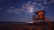 The moon hangs low in the sky casting an eerie glow on the abandoned lifeguard tower and rusted beach chairs. . .