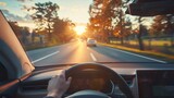 Fototapeta Na sufit - An electric car driver drives an EV at sunset with a blurred sky view inside the car with the car's steering wheel held in his hands