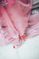 Wall Mural - Closeup detail of bride putting on high heeled sandal wedding shoes. Selective focus.