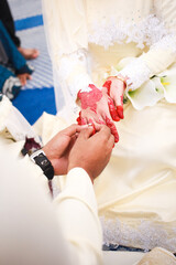 Wall Mural - Groom put a ring on finger of his lovely wife. Close up image and selective focus.