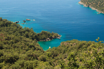 View onto the turquoise colored Mersinli Koyu Bay with an anchored boat in it, near Kayaköy, Fethiye, Turkey